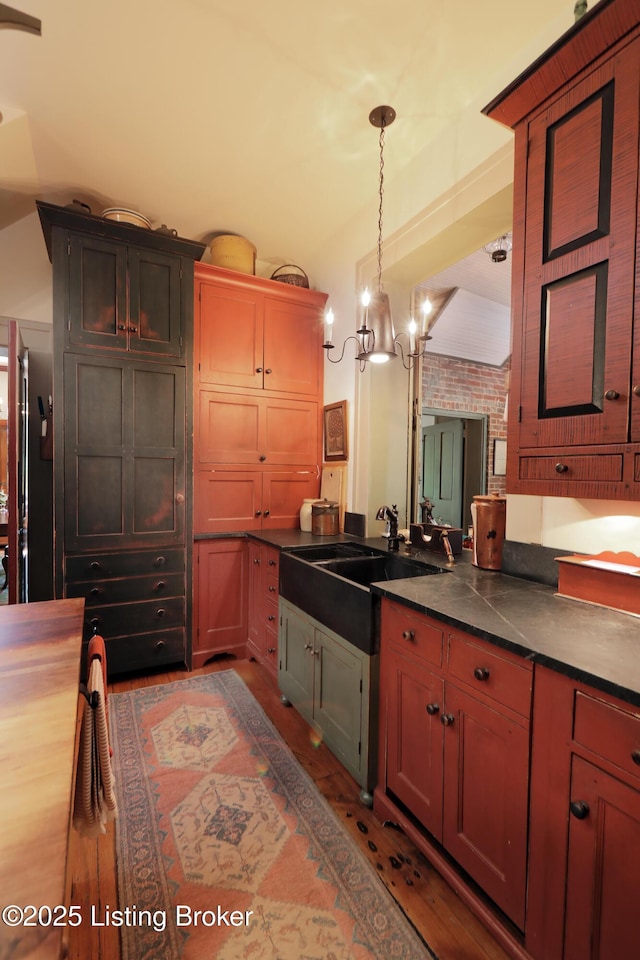 2406 Tucker Station Rd, Louisville, KY 40299 - kitchen with dark countertops, light wood-type flooring, pendant lighting, and a chandelier