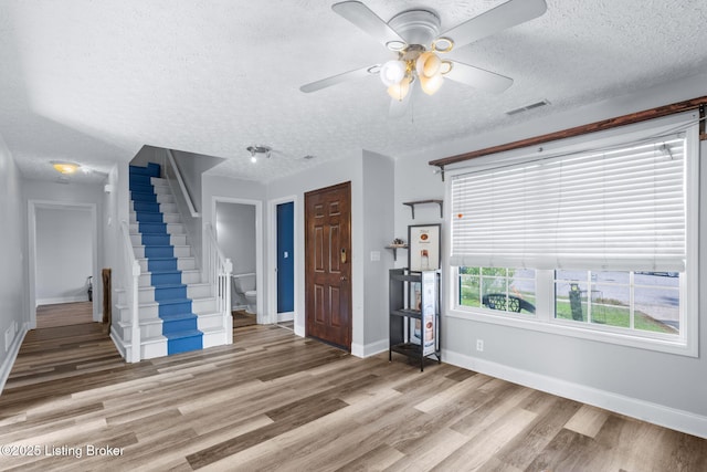 128 Clover Cove Ct, Shepherdsville, KY 40165 - unfurnished living room with a textured ceiling, stairway, light wood-style flooring, and a ceiling fan