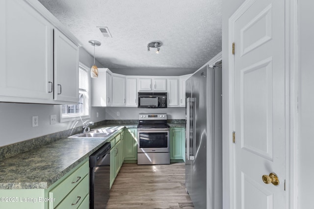 128 Clover Cove Ct, Shepherdsville, KY 40165 - kitchen with stainless steel appliances, green cabinetry, white cabinetry, light wood finished floors, and dark countertops