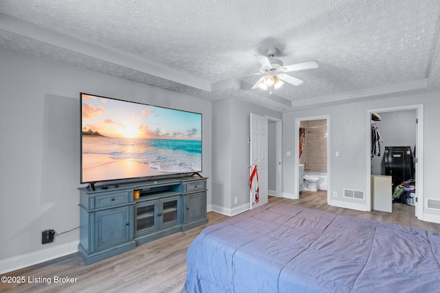 128 Clover Cove Ct, Shepherdsville, KY 40165 - bedroom with a textured ceiling, light wood-style floors, a walk in closet, ensuite bathroom, and ceiling fan