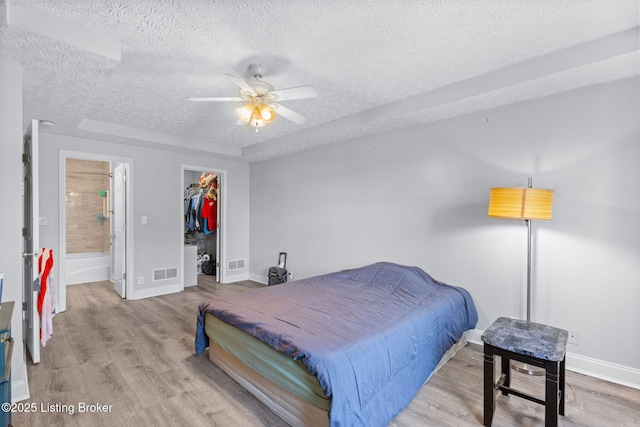 128 Clover Cove Ct, Shepherdsville, KY 40165 - bedroom featuring a textured ceiling, wood finished floors, a walk in closet, a closet, and a ceiling fan