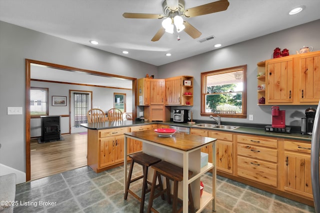 2883 Sweeney Ln, Pleasureville, KY 40057 - kitchen featuring open shelves, a wood stove, dark countertops, a peninsula, and healthy amount of natural light