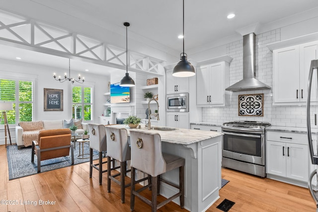 6331 Mistflower Cir, Prospect, KY 40059 - kitchen featuring stainless steel appliances, wall chimney range hood, light wood-style floors, white cabinetry, and tasteful backsplash