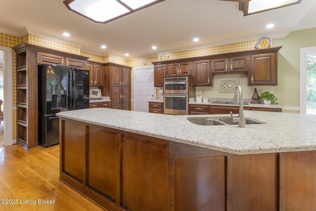 7005 New Bern Ct, Prospect, KY 40059 - kitchen featuring black appliances, ornamental molding, light stone counters, light wood-type flooring, and dark brown cabinets