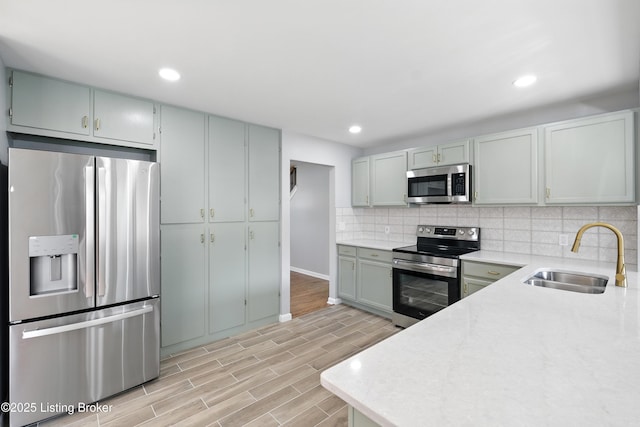 6505 Ridge Cliff Rd, Hollow Creek, KY 40228 - kitchen featuring appliances with stainless steel finishes, tasteful backsplash, light wood-style flooring, and recessed lighting