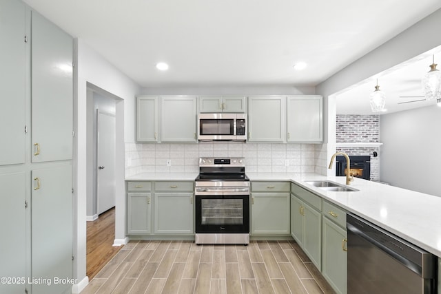 6505 Ridge Cliff Rd, Hollow Creek, KY 40228 - kitchen featuring appliances with stainless steel finishes, a fireplace, backsplash, light countertops, and ceiling fan