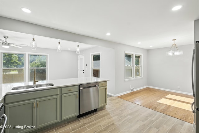 6505 Ridge Cliff Rd, Hollow Creek, KY 40228 - kitchen featuring appliances with stainless steel finishes, green cabinetry, light wood-type flooring, hanging light fixtures, and light countertops