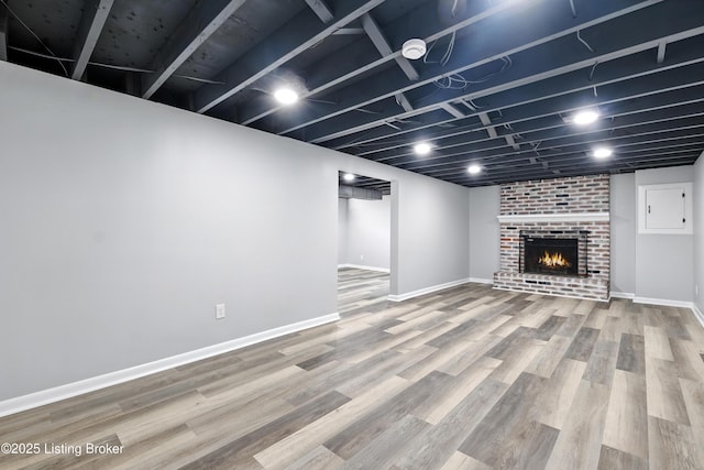 6505 Ridge Cliff Rd, Hollow Creek, KY 40228 - finished basement with a brick fireplace, electric panel, and wood finished floors