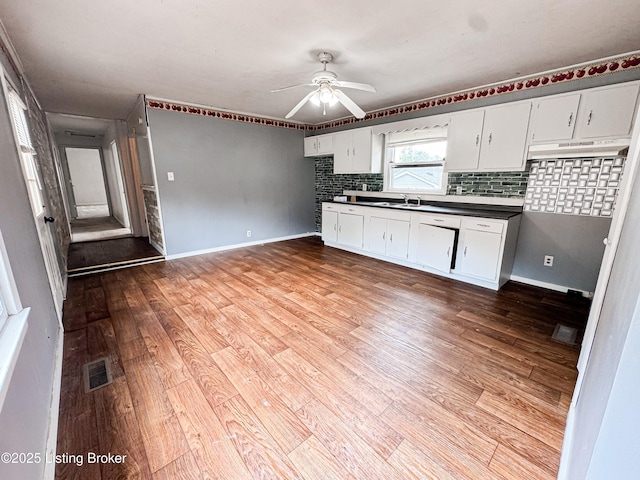 108 Bruce St, Lebanon Junction, KY 40150 - kitchen featuring dark countertops, ceiling fan, backsplash, wood finished floors, and white cabinetry