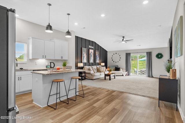 3001 Opal Dr, Shelbyville, KY 40065 - kitchen with a ceiling fan, light wood-style flooring, white cabinetry, a kitchen breakfast bar, and vaulted ceiling
