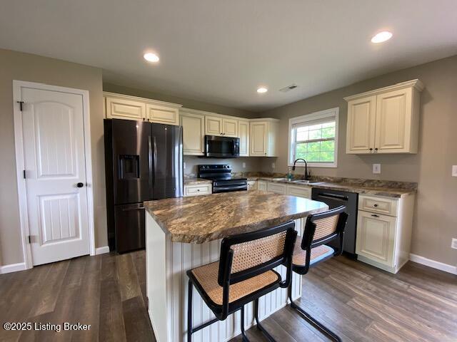 121 Redwood Dr, Bardstown, KY 40004 - kitchen with black appliances, dark wood-style flooring, a kitchen island, a breakfast bar, and recessed lighting