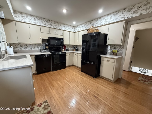 7206 Arrowwood Rd, Louisville, KY 40222 - kitchen featuring black appliances, light wood finished floors, light countertops, tasteful backsplash, and white cabinets