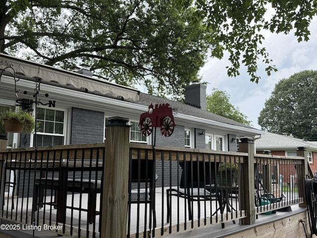 7206 Arrowwood Rd, Louisville, KY 40222 - view of front facade with brick siding, a chimney, a deck, and roof with shingles