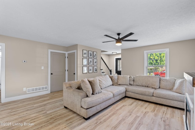 508 Auburn Oaks Dr, Louisville, KY 40214 - living room featuring light wood finished floors, ceiling fan, stairway, and a textured ceiling