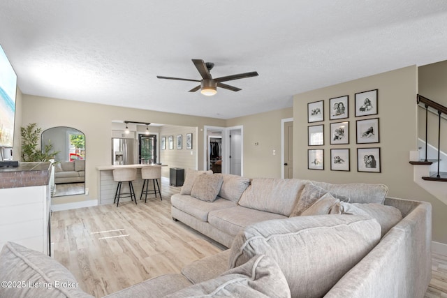 508 Auburn Oaks Dr, Louisville, KY 40214 - living room with light wood-style floors, a ceiling fan, stairway, healthy amount of natural light, and a textured ceiling