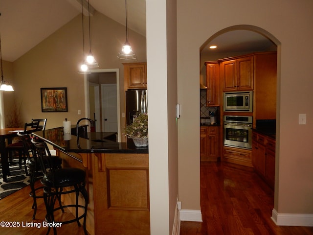 193 Pare Ct, Shepherdsville, KY 40165 - kitchen with stainless steel appliances, arched walkways, dark wood-type flooring, brown cabinetry, and beam ceiling