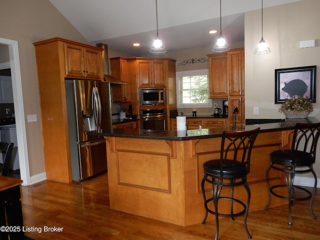 193 Pare Ct, Shepherdsville, KY 40165 - kitchen featuring appliances with stainless steel finishes, wood finished floors, dark countertops, wall chimney range hood, and a breakfast bar area