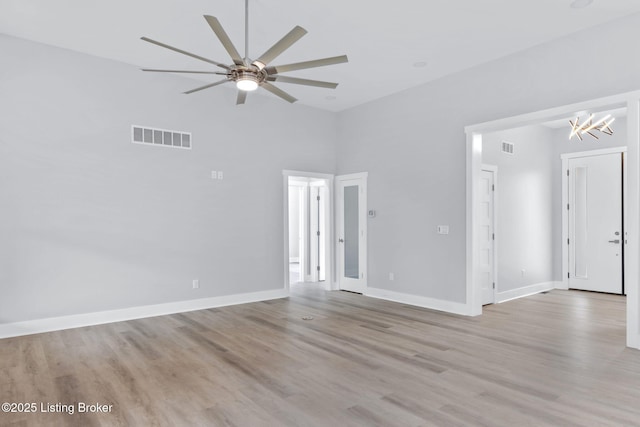 7103 Star Barn Ln, Crestwood, KY 40014 - spare room with ceiling fan, light wood-type flooring, a chandelier, and a towering ceiling