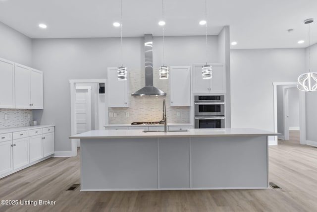 7103 Star Barn Ln, Crestwood, KY 40014 - kitchen with wall chimney exhaust hood, light countertops, tasteful backsplash, white cabinetry, and light wood-type flooring