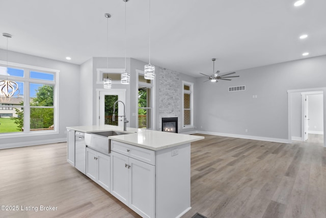 7103 Star Barn Ln, Crestwood, KY 40014 - kitchen with white dishwasher, a stone fireplace, recessed lighting, a kitchen island with sink, and white cabinetry