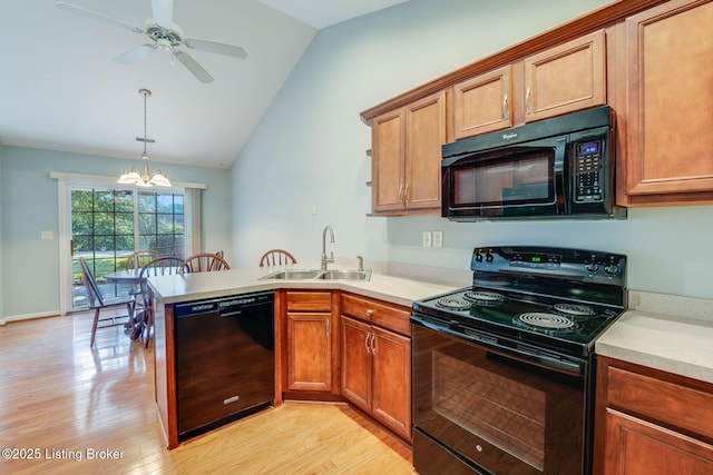 6708 Island Pointe Pl, Louisville, KY 40258 - kitchen featuring black appliances, a peninsula, a chandelier, light wood finished floors, and vaulted ceiling