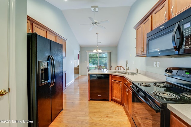 6708 Island Pointe Pl, Louisville, KY 40258 - kitchen with black appliances, lofted ceiling, brown cabinetry, light wood-style floors, and a peninsula