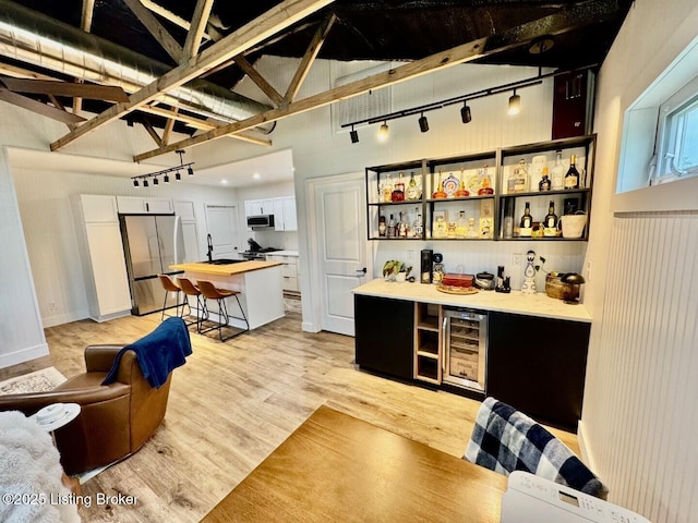 9068 Mackville Rd, Springfield, KY 40069 - indoor dry bar featuring stainless steel appliances, wine cooler, light wood-type flooring, and rail lighting