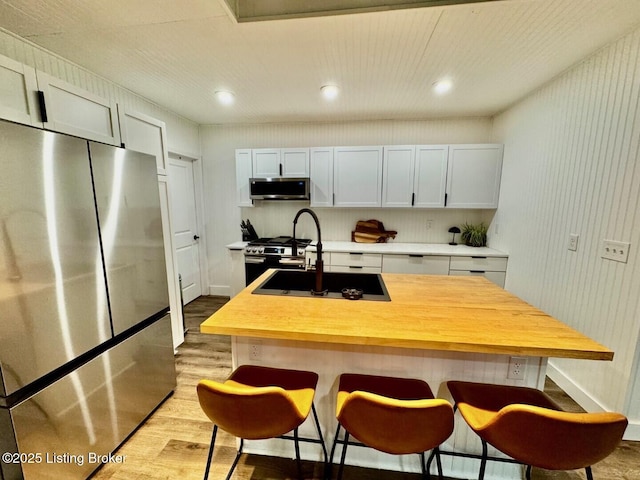9068 Mackville Rd, Springfield, KY 40069 - kitchen with appliances with stainless steel finishes, light wood-style floors, a kitchen breakfast bar, and recessed lighting