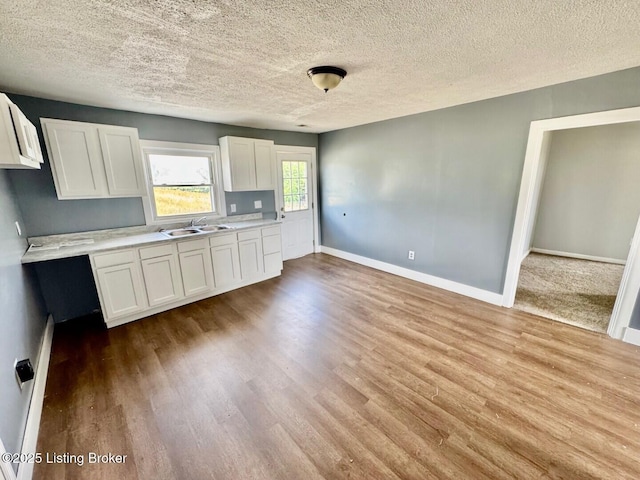 6234 Mackville Rd, Springfield, KY 40069 - kitchen featuring white cabinetry, wood finished floors, a textured ceiling, and light countertops