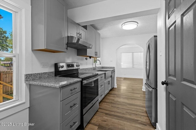 428 Pennsylvania Ave, Elizabethtown, KY 42701 - kitchen featuring stainless steel appliances, under cabinet range hood, gray cabinetry, a textured ceiling, and arched walkways