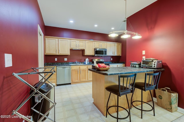 344 S Dorsey Ln Unit 344, Louisville, KY 40223 - kitchen featuring stainless steel appliances, dark countertops, a kitchen bar, light floors, and a peninsula