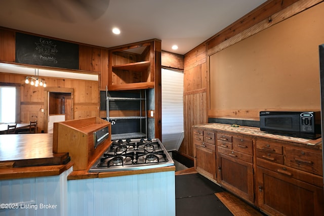 1819 Eastern Pkwy, Louisville, KY 40204 - kitchen with black microwave, stainless steel gas stovetop, recessed lighting, and wood walls