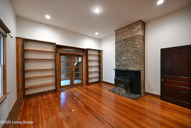 1819 Eastern Pkwy, Louisville, KY 40204 - unfurnished living room featuring french doors, hardwood / wood-style floors, a wood stove, and recessed lighting