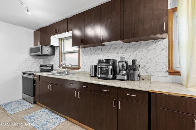 1775 Wathen Ln, Louisville, KY 40216 - kitchen featuring stainless steel appliances, dark brown cabinetry, backsplash, and light tile patterned flooring