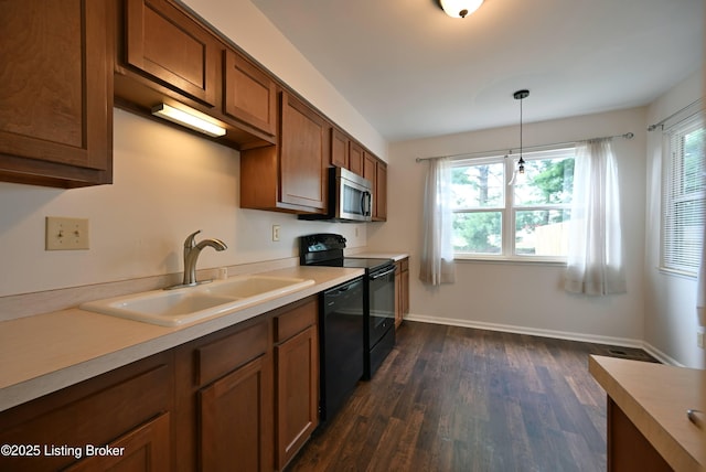 8705 Clover Ct, Louisville, KY 40242 - kitchen with black appliances, brown cabinetry, light countertops, and pendant lighting