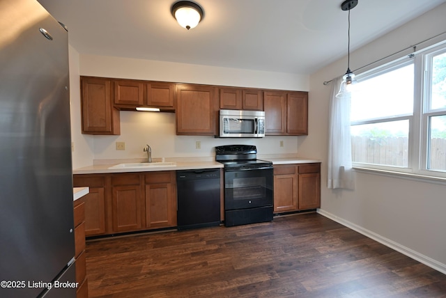 8705 Clover Ct, Louisville, KY 40242 - kitchen featuring black appliances, light countertops, brown cabinets, dark wood-type flooring, and hanging light fixtures