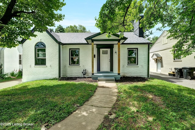 2620 Algonquin Pkwy, Louisville, KY 40210 - view of front facade with brick siding, a chimney, a front yard, and roof with shingles