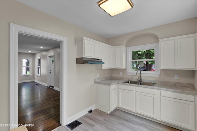 2620 Algonquin Pkwy, Louisville, KY 40210 - kitchen featuring light wood-style flooring, under cabinet range hood, healthy amount of natural light, white cabinets, and recessed lighting