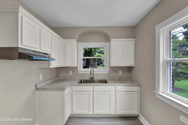 2620 Algonquin Pkwy, Louisville, KY 40210 - kitchen with under cabinet range hood, plenty of natural light, and white cabinetry