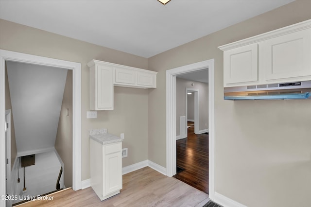 2620 Algonquin Pkwy, Louisville, KY 40210 - kitchen with under cabinet range hood, light wood finished floors, white cabinets, and light countertops