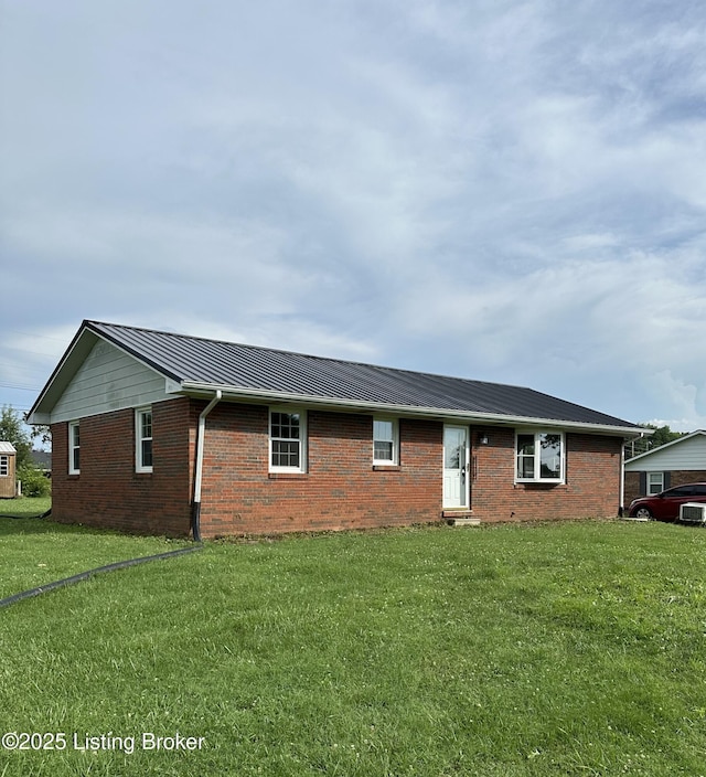 106 Sunflower Dr, Campbellsville, KY 42718 - view of front of property featuring brick siding, a front lawn, a standing seam roof, and a metal roof