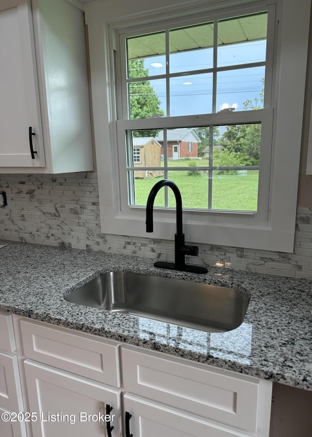 106 Sunflower Dr, Campbellsville, KY 42718 - kitchen view of decorative backsplash, white cabinetry, and light stone counters
