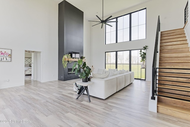 1160 Equestrian Lakes Ln, Finchville, KY 40022 - living area with a high ceiling, stairway, ceiling fan, and light wood finished floors