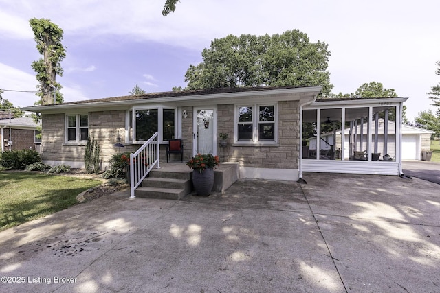 10703 Cedar Creek Rd, Louisville, KY 40229 - view of front of home featuring stone siding, driveway, a sunroom, and a front yard