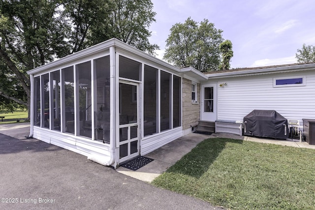 10703 Cedar Creek Rd, Louisville, KY 40229 - rear view of house featuring a sunroom, entry steps, and a lawn