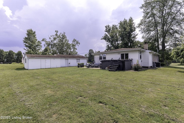 10703 Cedar Creek Rd, Louisville, KY 40229 - back of house featuring a hot tub, a chimney, and a lawn