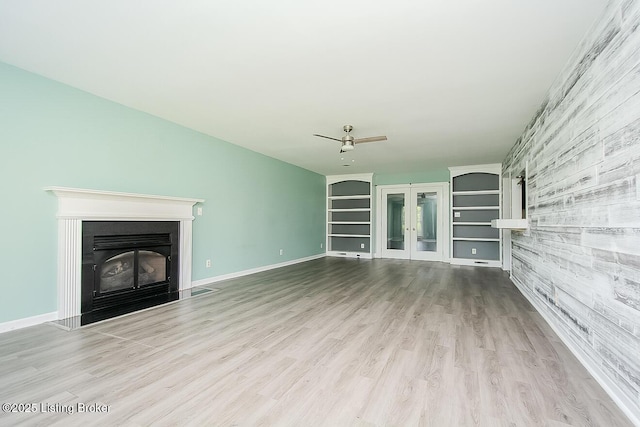 315 Tophill Dr, Shelbyville, KY 40065 - unfurnished living room featuring a glass covered fireplace, french doors, ceiling fan, wood finished floors, and built in shelves