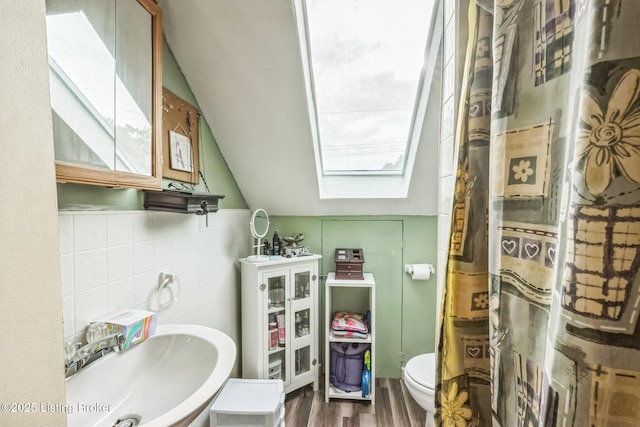 4418 Mann Ave, Louisville, KY 40215 - bathroom featuring a skylight, tile walls, wood finished floors, and lofted ceiling