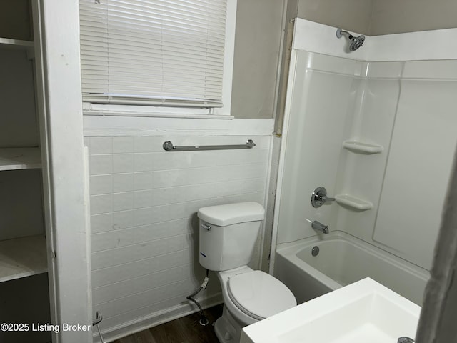 1851 Date St, Louisville, KY 40210 - bathroom featuring shower / bath combination, wood finished floors, tile walls, and a wainscoted wall