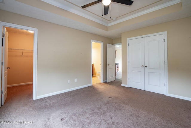 128 Boone Trce, Radcliff, KY 40160 - unfurnished bedroom with a closet, a tray ceiling, carpet, crown molding, and a walk in closet